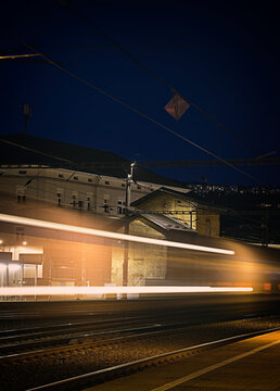 Night passage of a railway train. Blurred movement of a train at a railway station