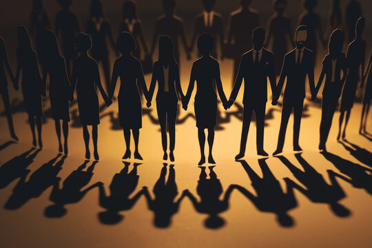 Paper cutouts of diverse business people holding hands in a circle with long radial shadows. Concept of global teamwork, unity, diversity, and strong community network.
