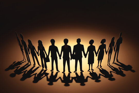 Paper cutouts of diverse business people holding hands in row with long shadow on warm background. Concept of teamwork, unity, partnership, and community support.