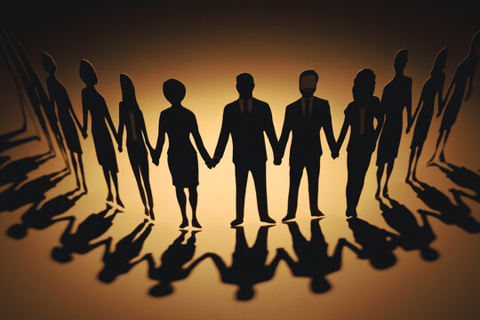 Paper cutouts of diverse business people holding hands in row with long shadow on warm background. Concept of teamwork, unity, partnership, and community support.
