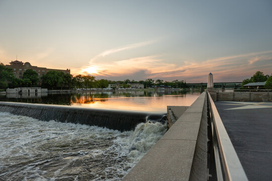 Water flowing over a river dam at sunset