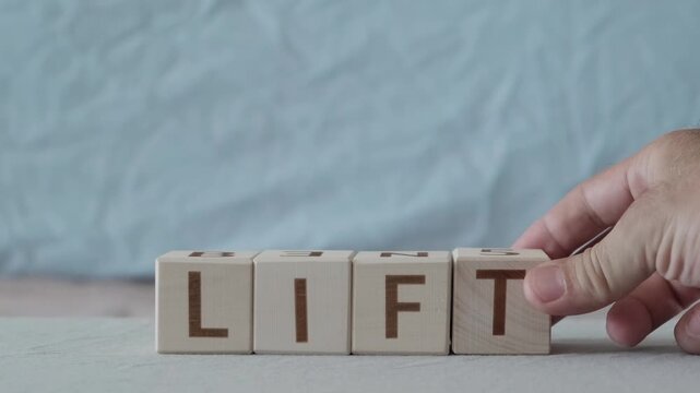 lift, motivational word, laying out  by hand from letters on wooden cubes, slow motion
