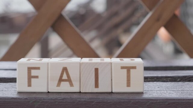 faith, motivational word, laying out  by hand from letters on wooden cubes, slow motion
