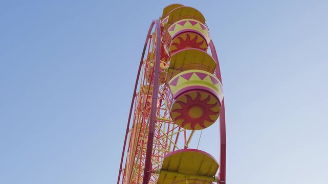 ferris wheel attraction is spinning, at day, side view, slow motion
