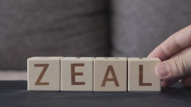 zeal, motivational word, laying out  by hand from letters on wooden cubes, slow motion
