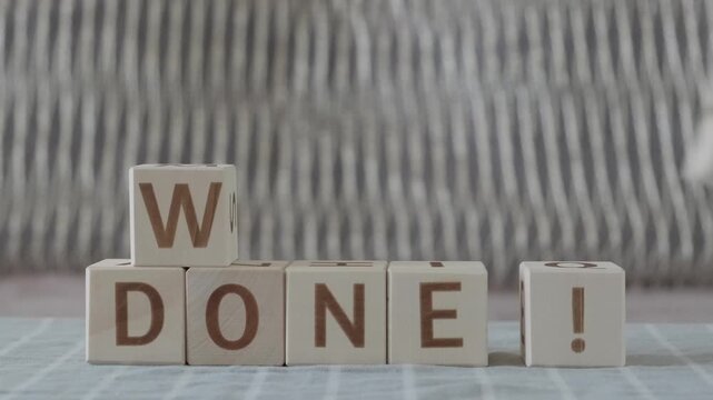 well done !, motivational phrase, laying out  by hand from letters on wooden cubes, slow motion
