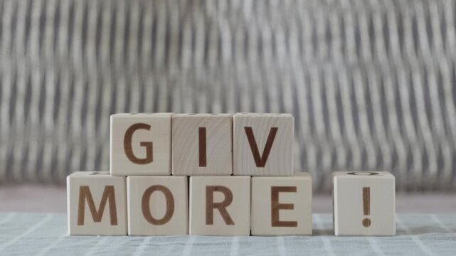 Give more!, laying out  by hand from letters on wooden cubes, slow motion

