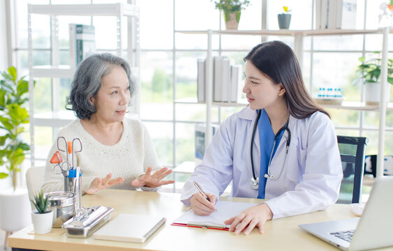 Asian professional young female doctor consulting senior woman patient in private hospital clinic attentive therapist comfort support medical service for older lady retiree people healthcare wellness.