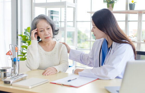 Asian professional young female doctor consulting senior woman patient in private hospital clinic attentive therapist comfort support medical service for older lady retiree people healthcare wellness.