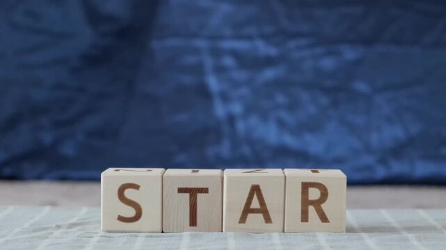 star, motivational word, laying out  by hand from letters on wooden cubes, slow motion
