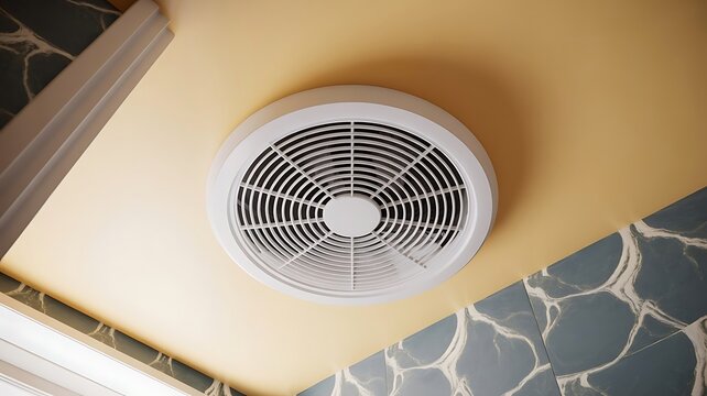 White circular ceiling ventilation fan installed on a smooth yellow ceiling with decorative blue and white marble wall tiles in a modern room