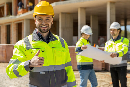 Happy male constructor showing thumb up sign