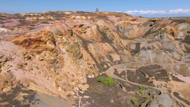 Parys Mountain Copper Mine, Amlwych, Anglesey, Wales, UK. Flight over main crater towards derelict windmill on hilltop