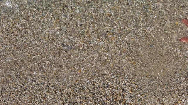 Top down view showing natural sandy gravel ground texture with subtle color variation across the surface