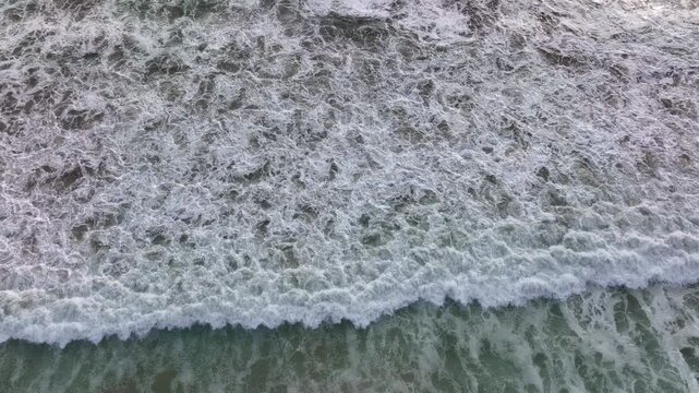 Waves rolling over sand. Sea water creating waves. Ocean wave crashing. Sea waves flowing to beach.