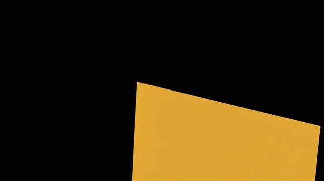 A sharp corner of a gold-colored geometric shape is set against a deep black background.