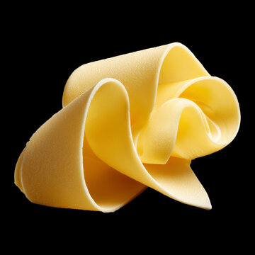 Curled butter swirl shown closeup isolated on black background with clipping path, concept of dairy food freshness