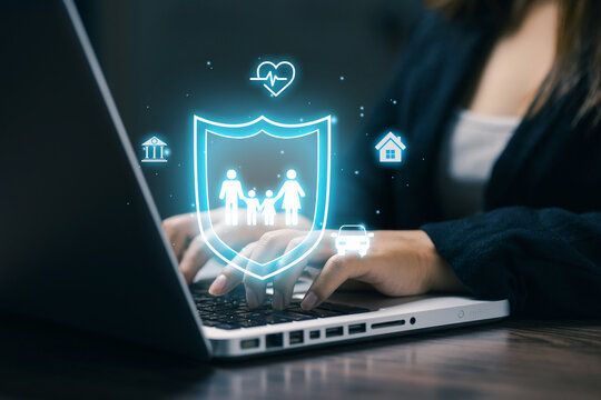 Business professional using laptop with virtual insurance shield and family icons, illustrating financial protection, life insurance, healthcare, home, vehicle, and digital coverage.