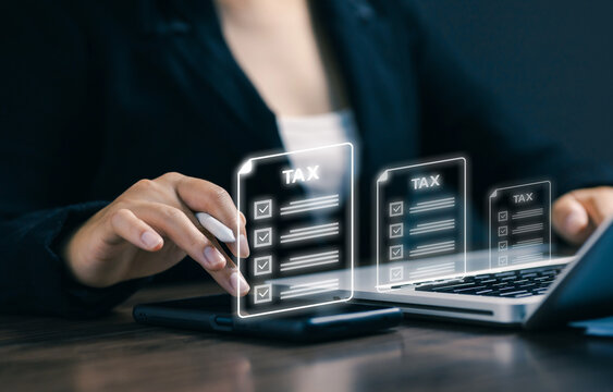 Business professional reviewing digital tax documents on laptop and tablet, illustrating online tax filing, accounting, financial compliance, bookkeeping, and electronic document management.