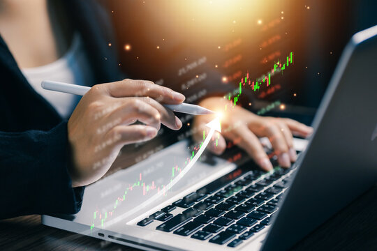 Financial analyst using laptop and digital pen with rising stock market chart, illustrating investment growth, trading strategy, market analysis, finance technology, and business profit.