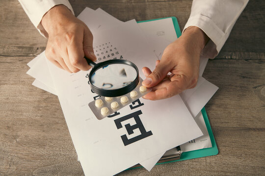 Doctor with stethoscope and prescription drug on table, closeup