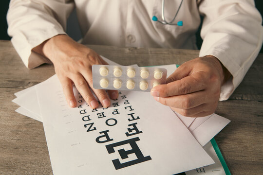 Doctor with stethoscope and prescription drug on table, closeup