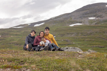 Fototapeta premium European family with children and pet dog, hiking Gorsabrua, the deepest canyon in Nortern Europe, with beautiful waterfall and bridge