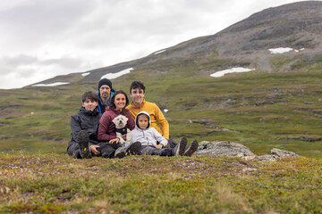 Fototapeta premium European family with children and pet dog, hiking Gorsabrua, the deepest canyon in Nortern Europe, with beautiful waterfall and bridge
