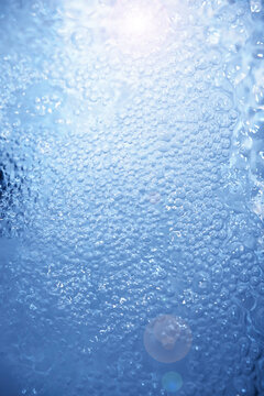 Bubbles and seething water in the light of sunlight.Blue water texture.