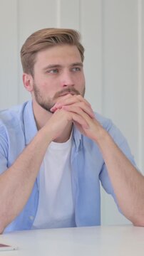Pensive Young Creative Man Sitting in Office Thinking, Vertical Video