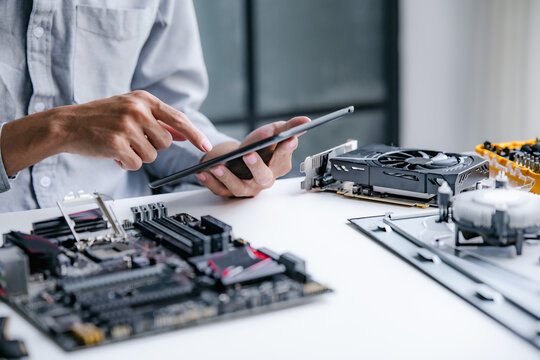 A computer technician fixes PC hardware in a professional engineering lab