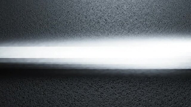 Radiant beam of bright white light traveling across a dark textured surface in this sleek animated motion video footage loop