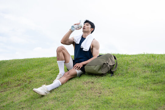 Athletic Asian Man Drinking Water After Outdoor Workout