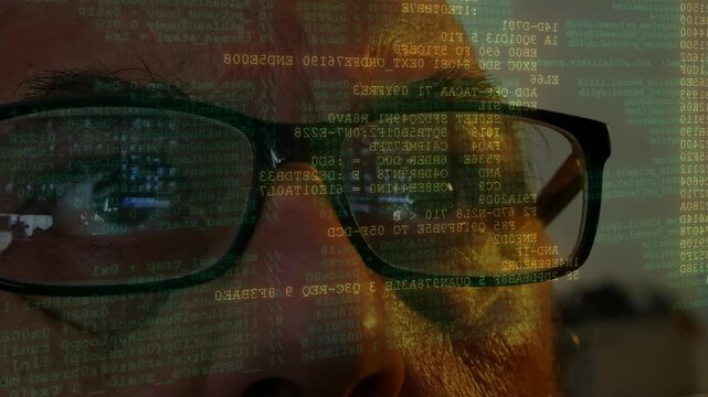 Man wearing glasses monitoring lines of code and data scanning displayed on front of his face