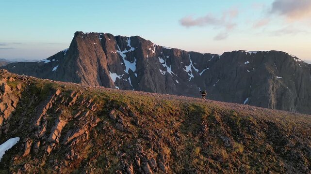 hiking ben nevis scotland highlands, aerial (drone) tracking shot, blue skies above north face cliffs of ben nevis