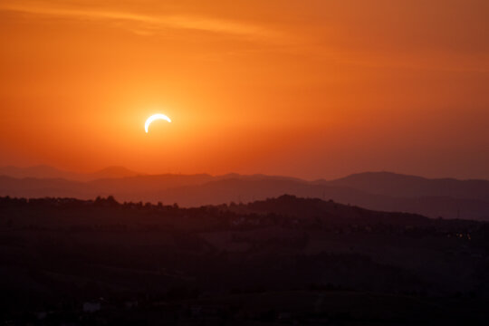 solar eclipse the moon obscures the sun sunset in the mountains