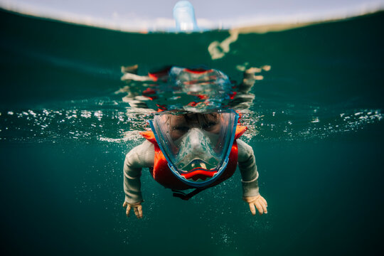 Young boy in a snorkel mask floating underwater