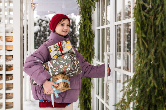 Teenage girl with Christmas presents entering house