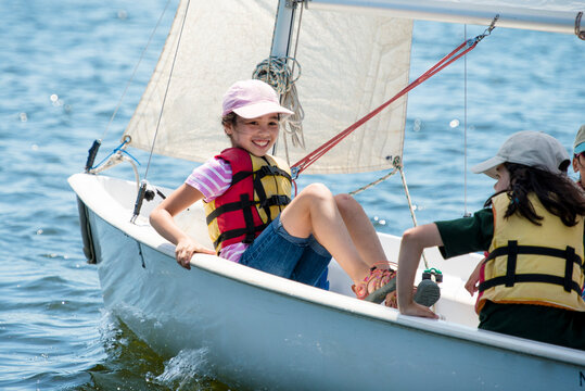 Happy young girl sailing in a small boat