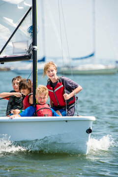 Happy kids having fun on a small sailboat