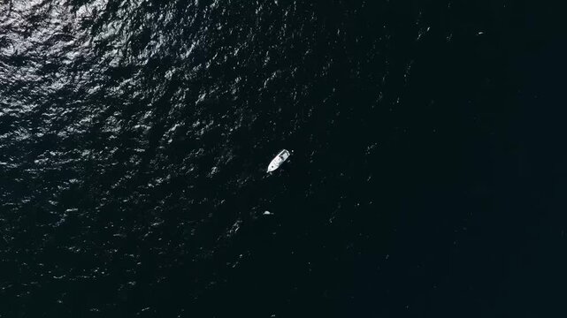 Traditional Greek fishing boat sailing in the deep blue open waters of the Ionian Sea off the coast of Corfu island, minimalist seascape with calm waves, Acharavi region, Greece, travel and maritime