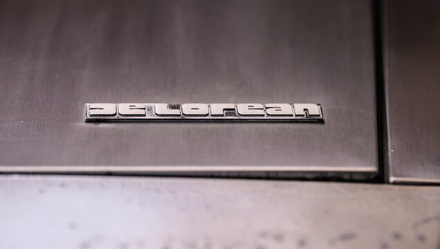 Gothenburg, Sweden - May 30 2026: Wide DeLorean hood badge detail with warm exhibition reflections.