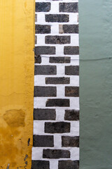Fototapeta premium Colorful yellow green wall with white brick column