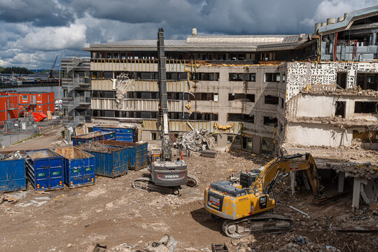 Gothenburg, Sweden - August 16 2021: Building demolition site with excavators and heavy machinery in action.