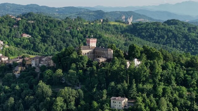 Panoramic shot of the rolling hills surrounding the medieval town of Guiglia under a blue sky