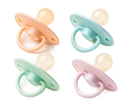 Four colorful baby pacifiers for newborns illustration