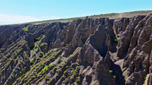 Aerial view of sharp soil ridges and deeply eroded ravines in a rugged badlands landscape in Anjihai Grand Canyon, Xinjiang, China