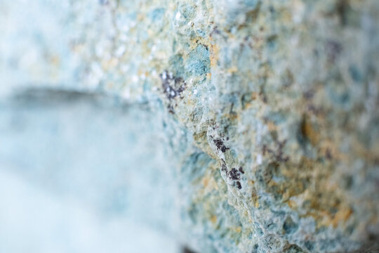 Selective focus of weathered stone surface shows faint erosion patterns.