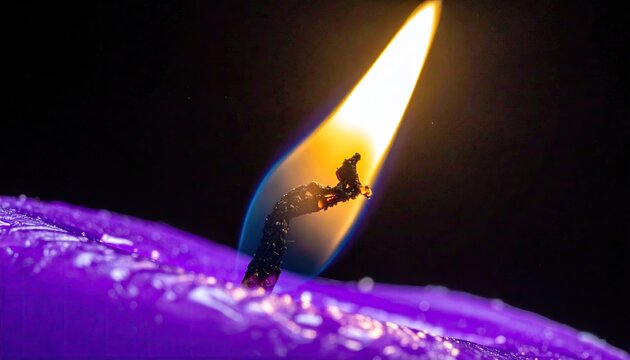 Burning purple candle wick with bright orange flame.