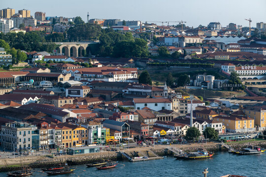 Vila Nova de Gaia, Portugal - 28 July 2026: View of the historic riverside with traditional port wine cellars, terracotta rooftops, and boats on the Douro River.